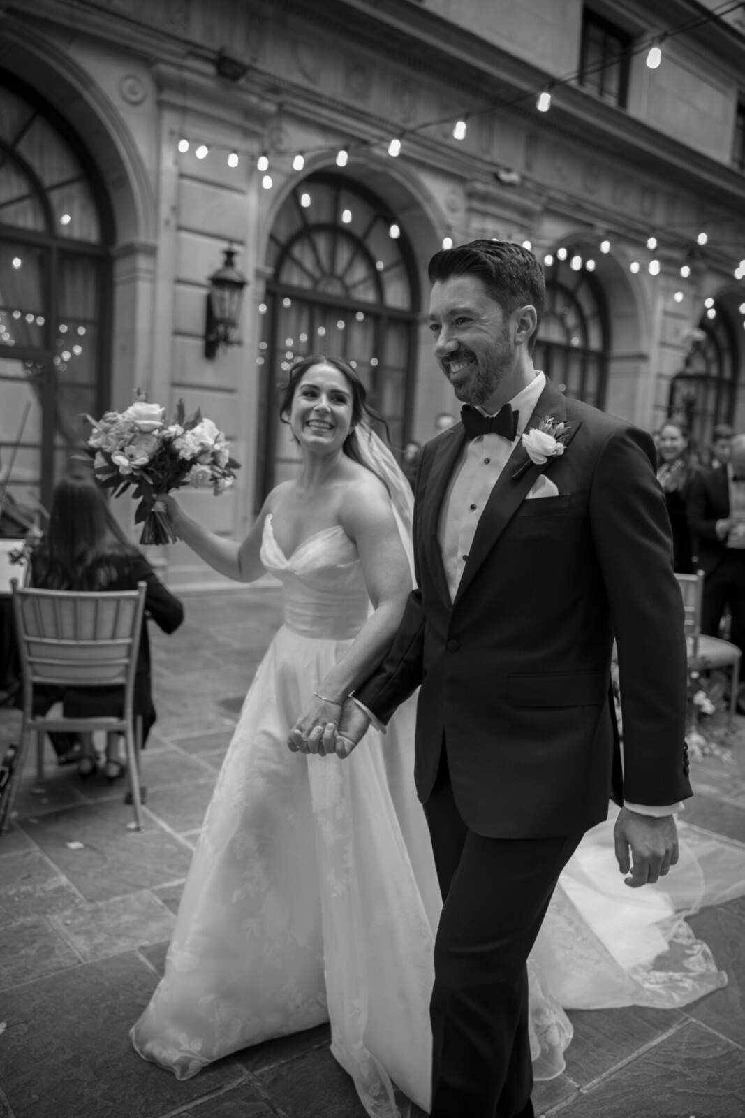 black and white photo of bride and groom walking