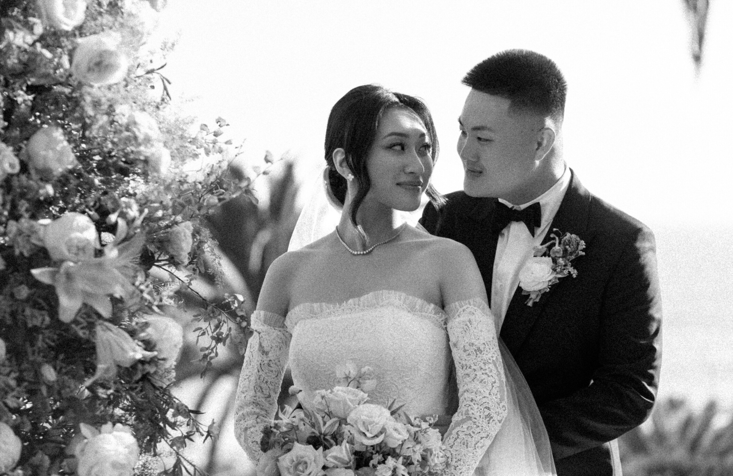 black and white bridal portrait of bride and groom looking at each other
